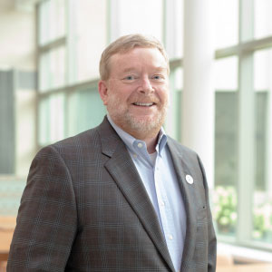 Charles Hasemann standing near windows