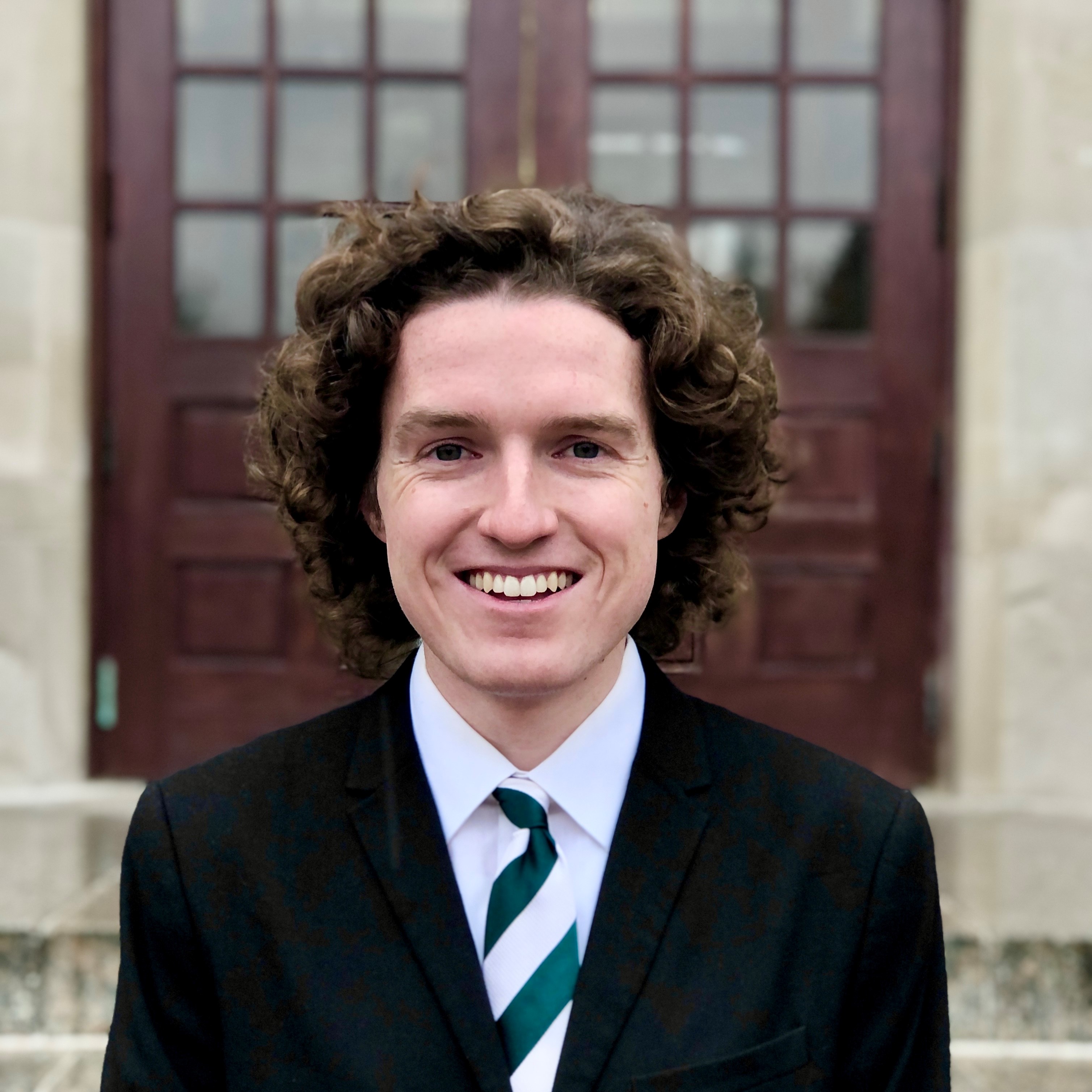 portrait photo of Andrew McDonald, young man with pale skin and brown curly hair