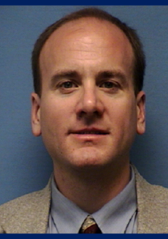 Head shot of John Albrecht, white male in suit and tie