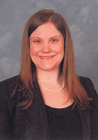 Portrait photo of Kristen Koritnik, woman with long brown hair in black top