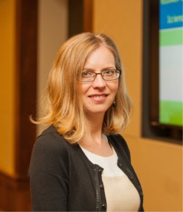 Portrait photo of Alex Burt, woman with blonde hair, glasses