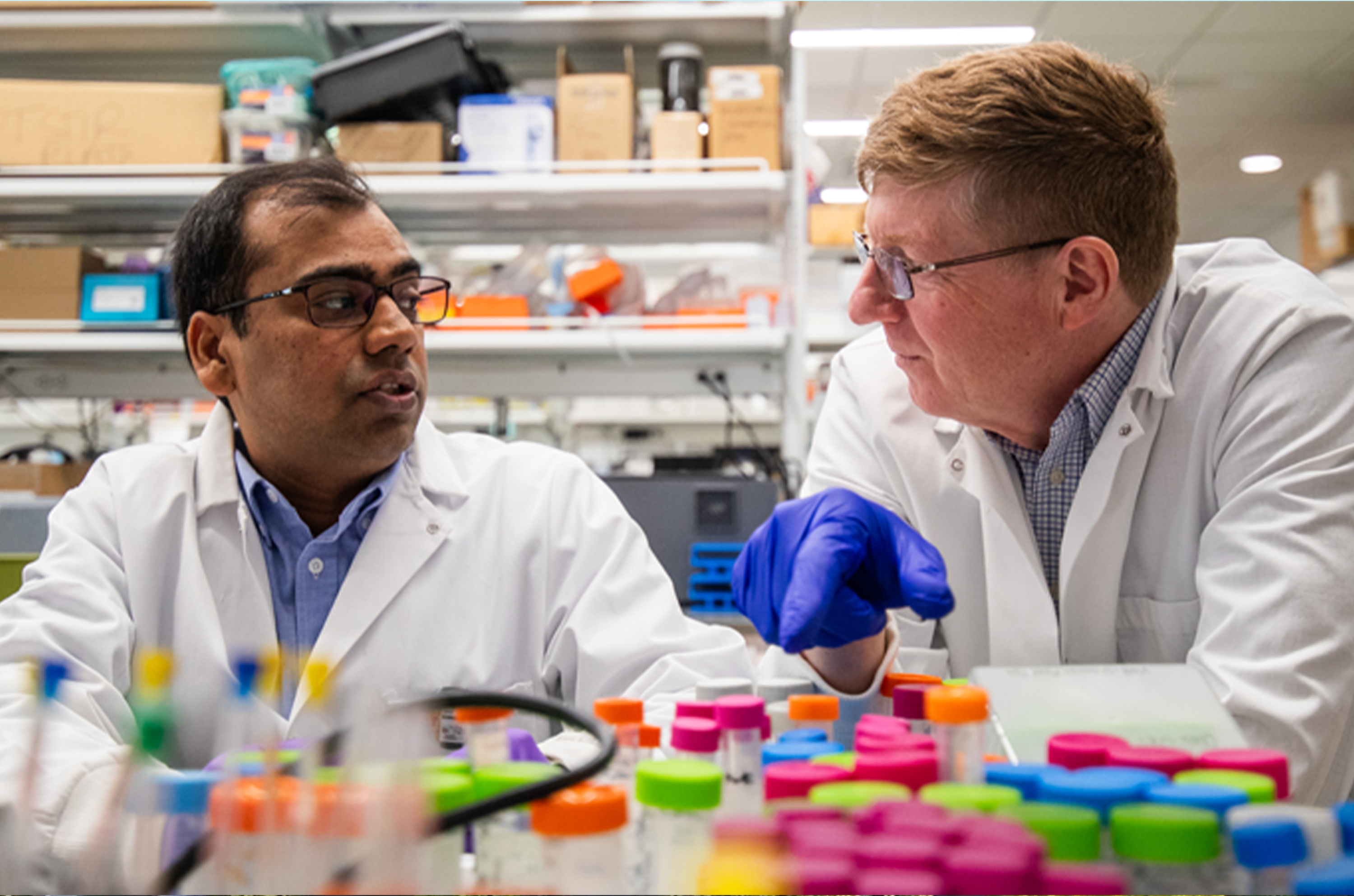 Two MSU researchers with many containers in the foreground