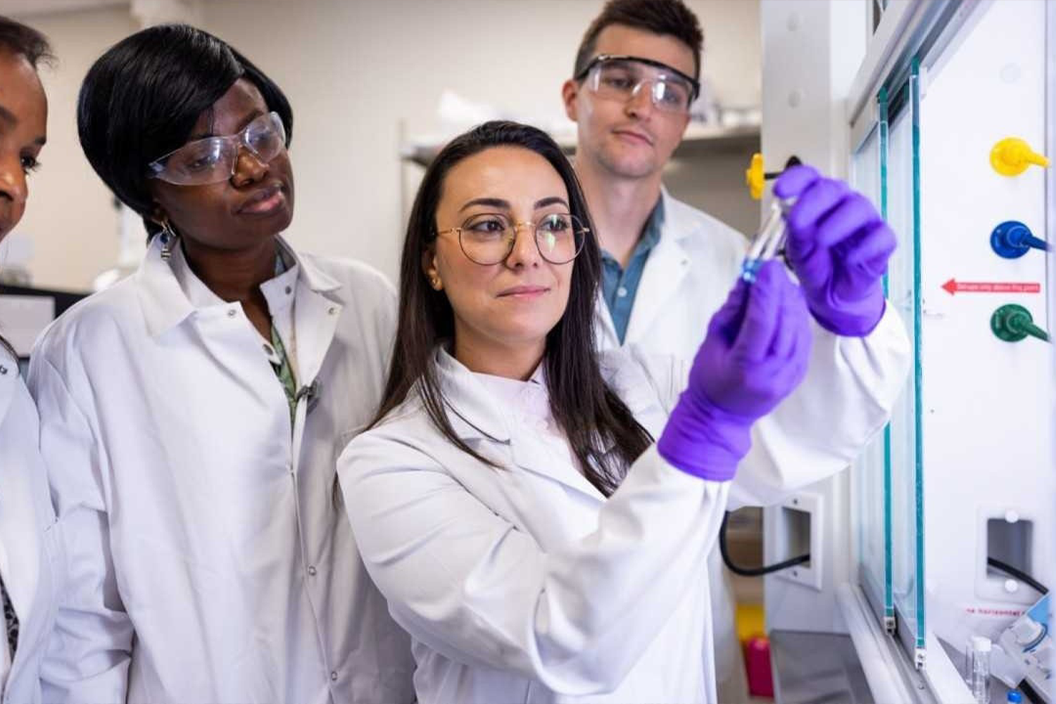 MSU Researchers looking at a glass tube