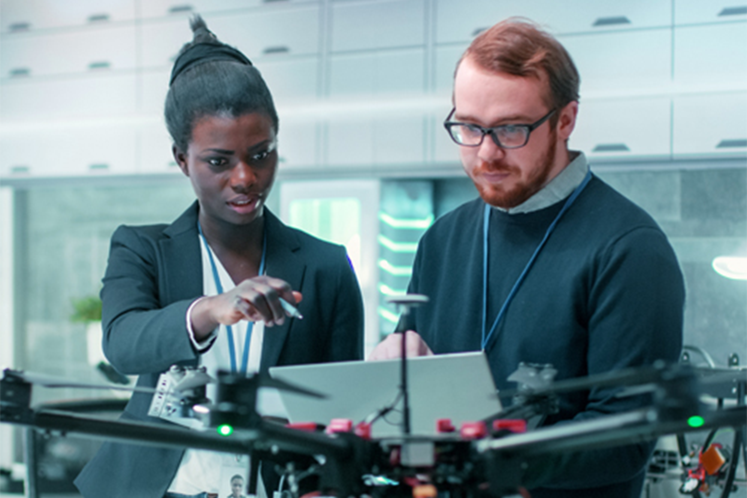 Two people looking at various technological machines. 