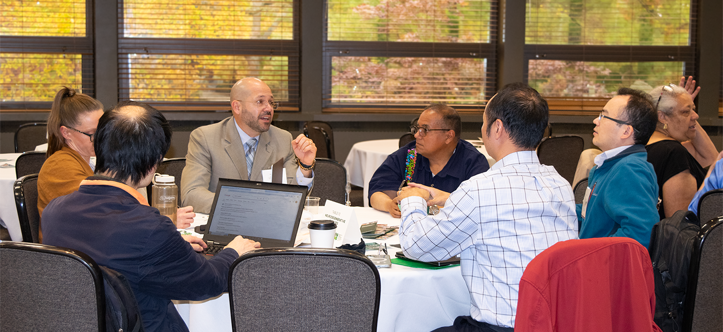 A group of people, working during a symposium discussion. 