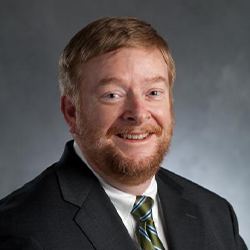 Charles Hasemann Posing for Headshot in Suit