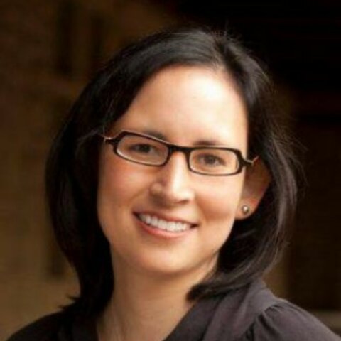 A woman with medium-length dark hair and glasses