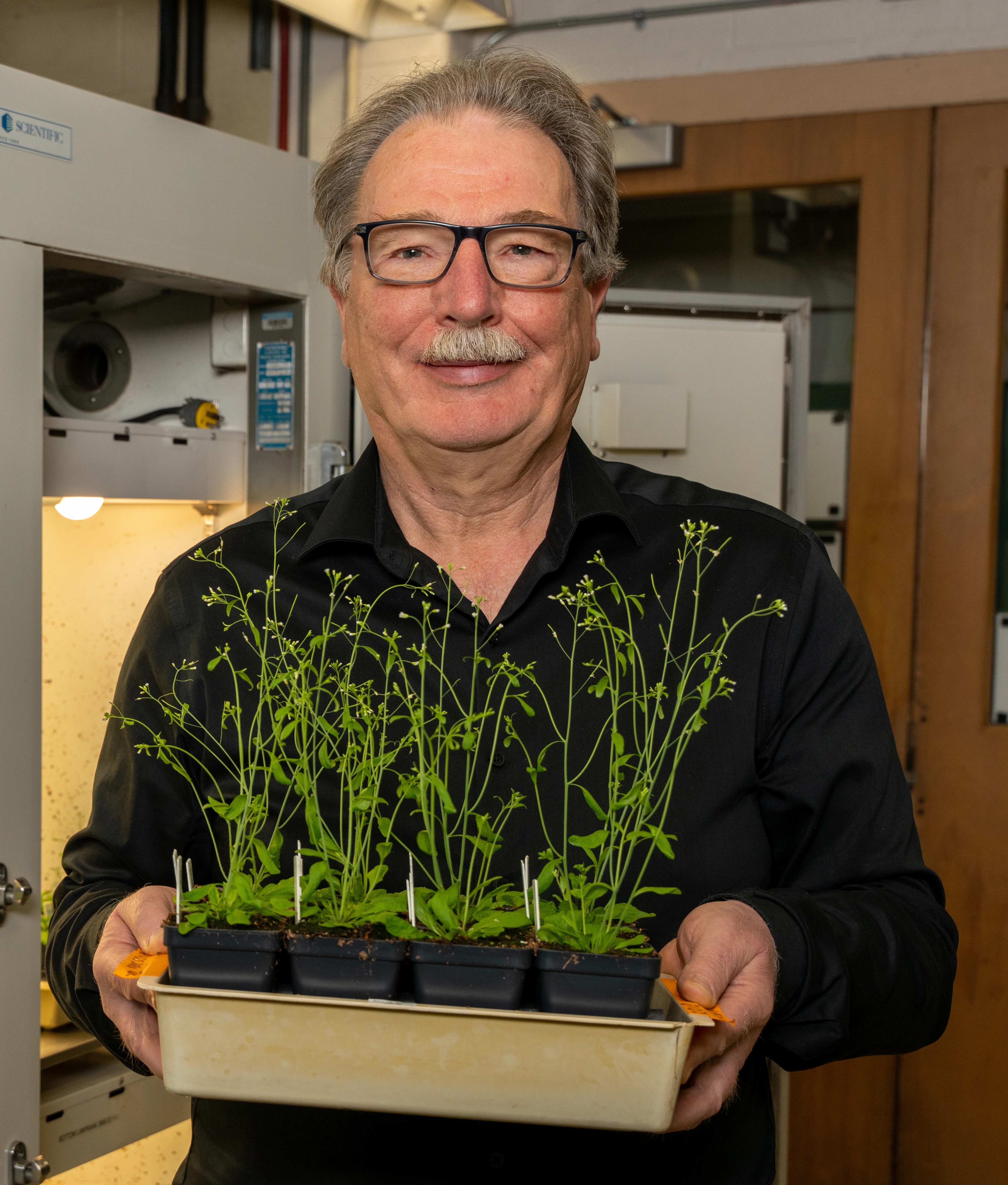Christoph Benning smiling holding a plant tray
