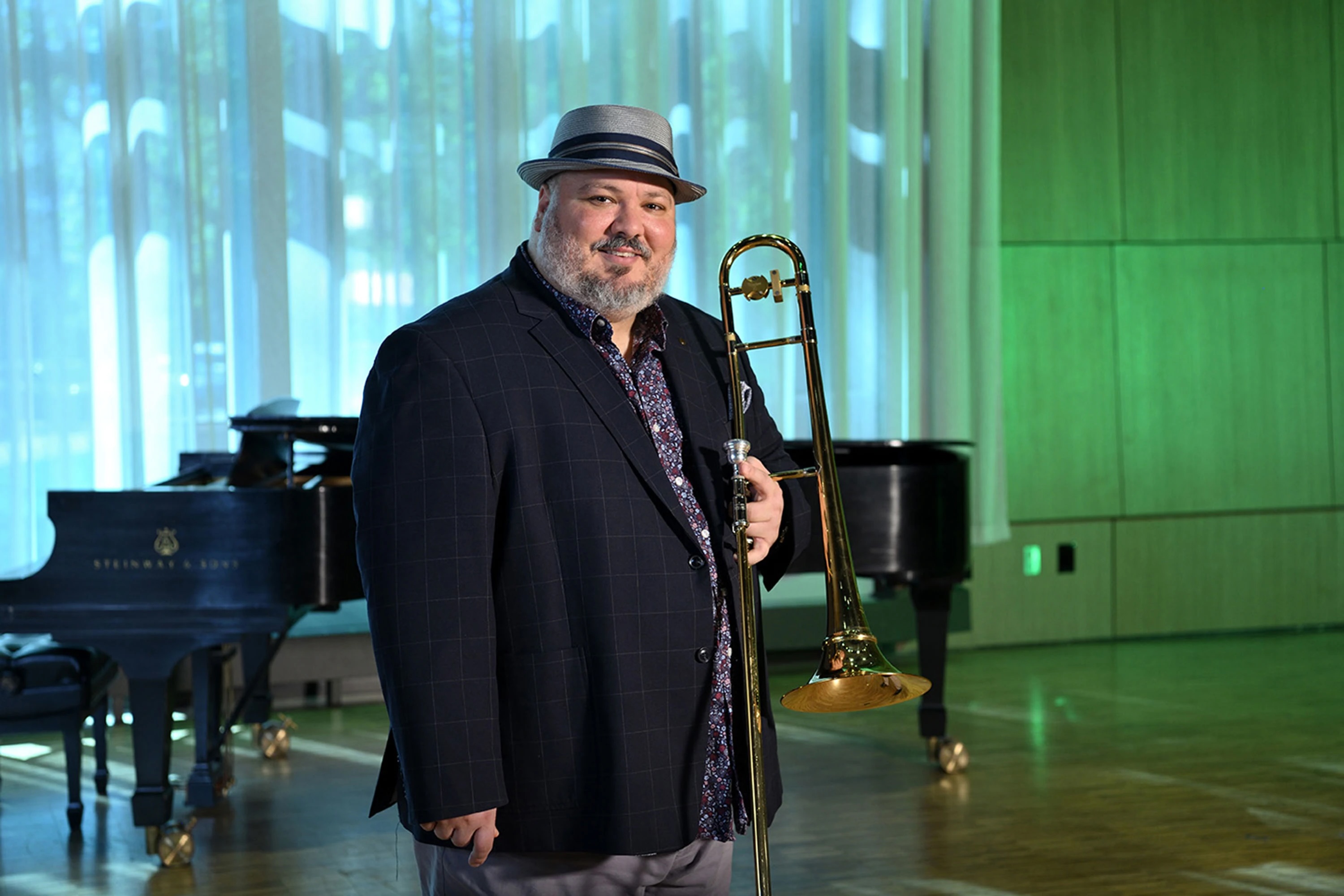 Micheal Dease smiling in a suit and hat