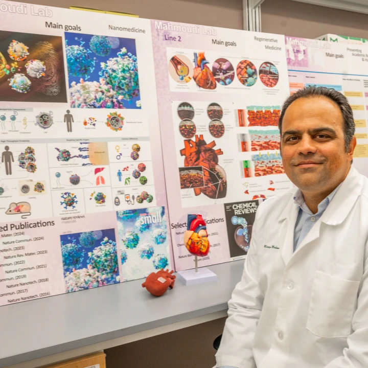 Morteza Mahmoudi in lab coat in front of presentation