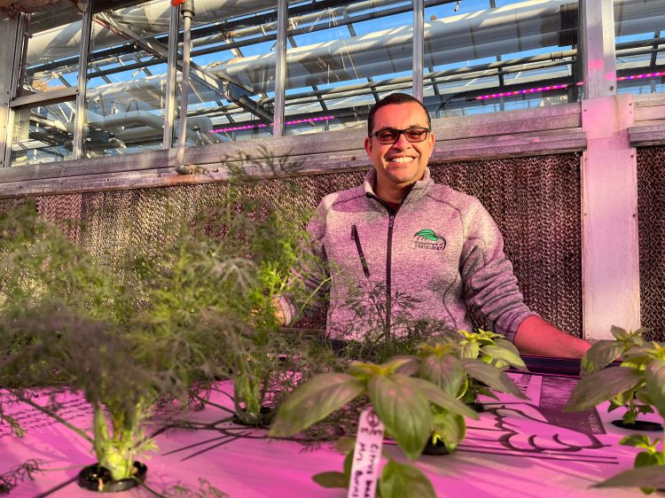 Roberto Lopez smiling by plants