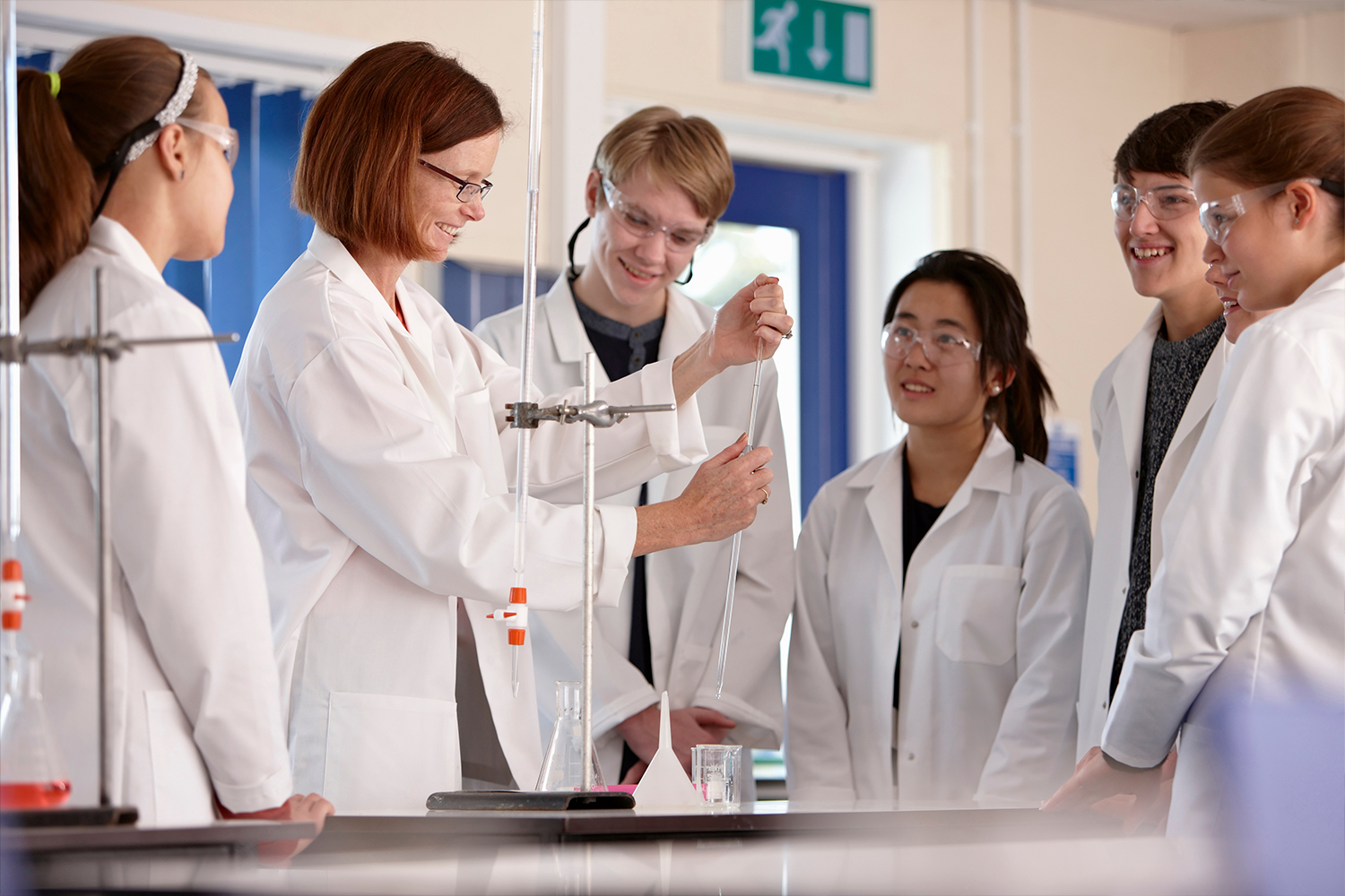 A group of people in a lab wering white coats using a test tube