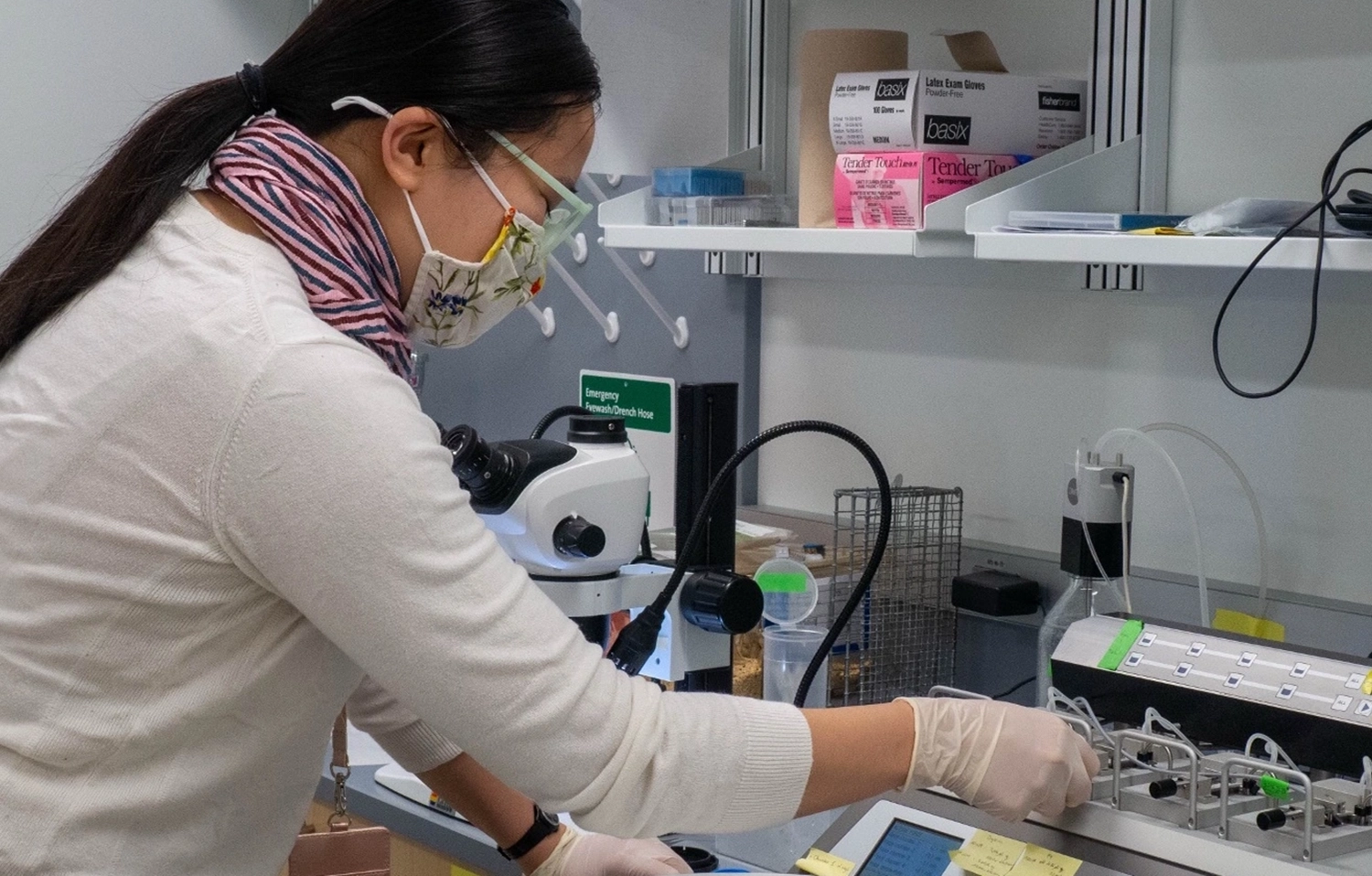 Woman with mask working at lab bench