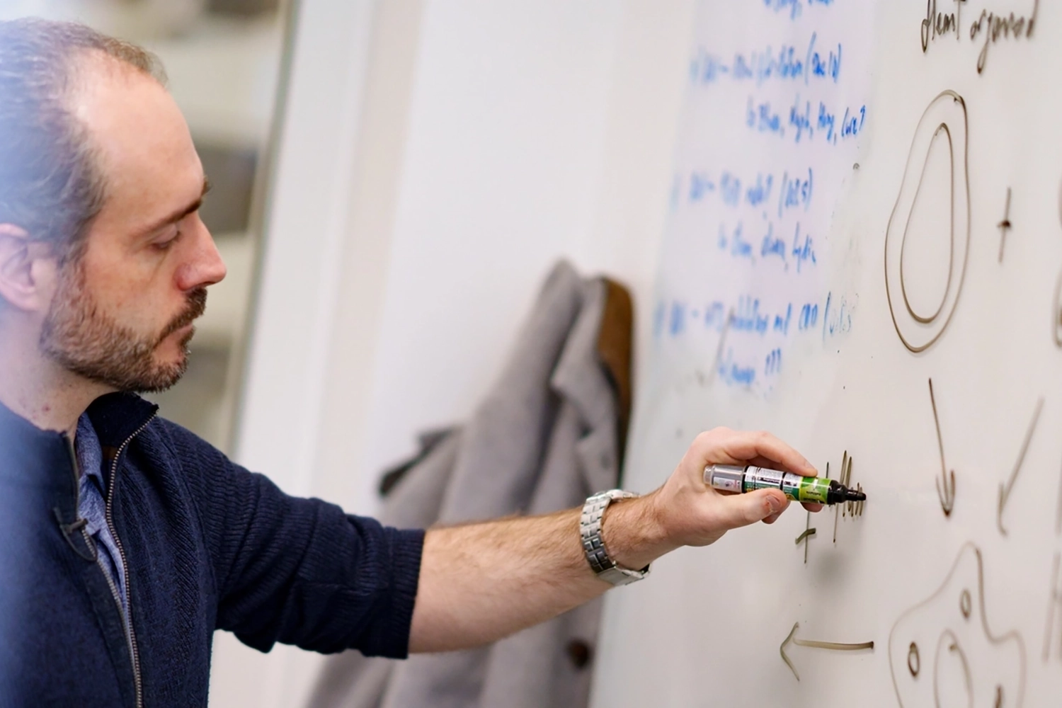Man writing formulas on white board