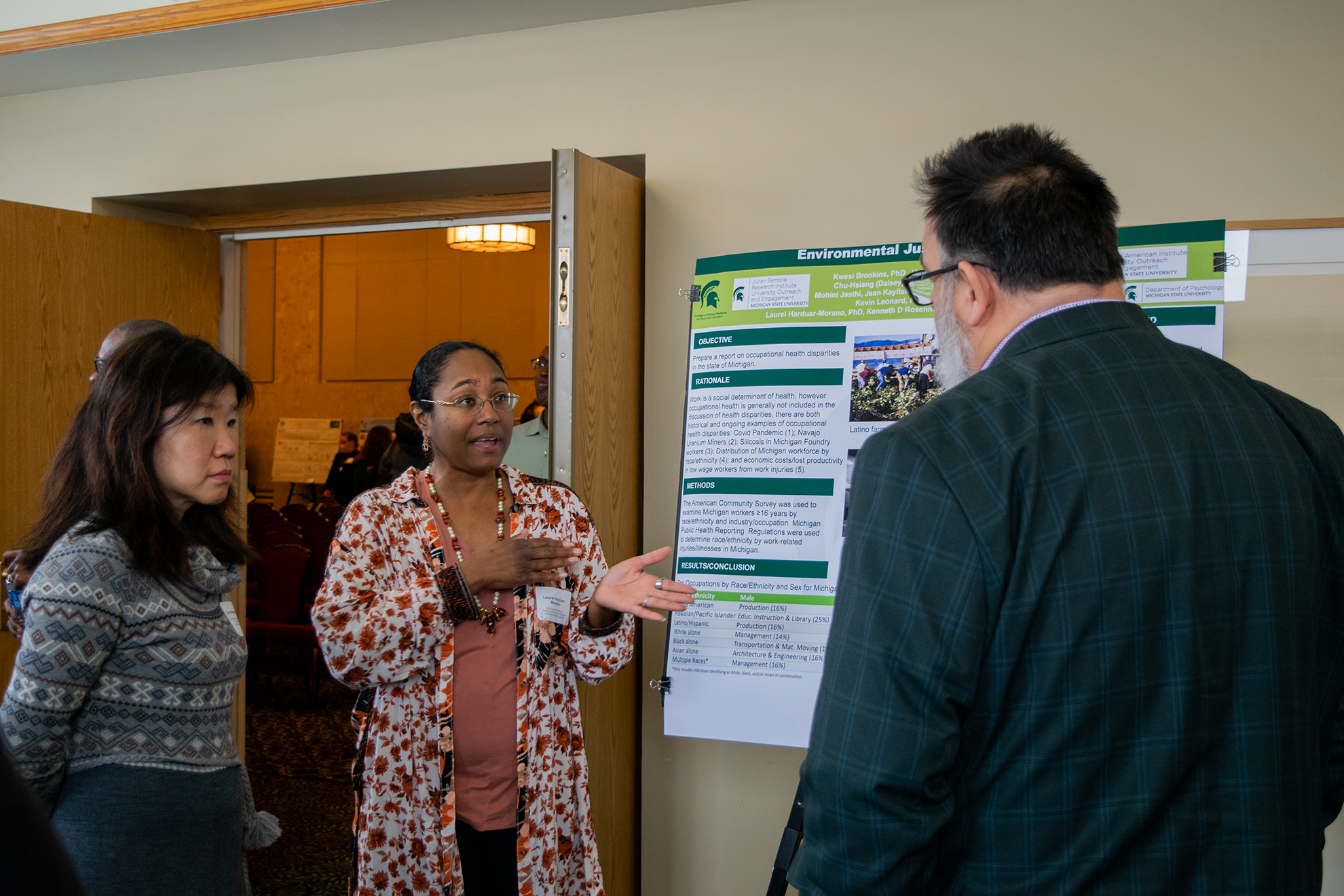 People talking in front of a research poster