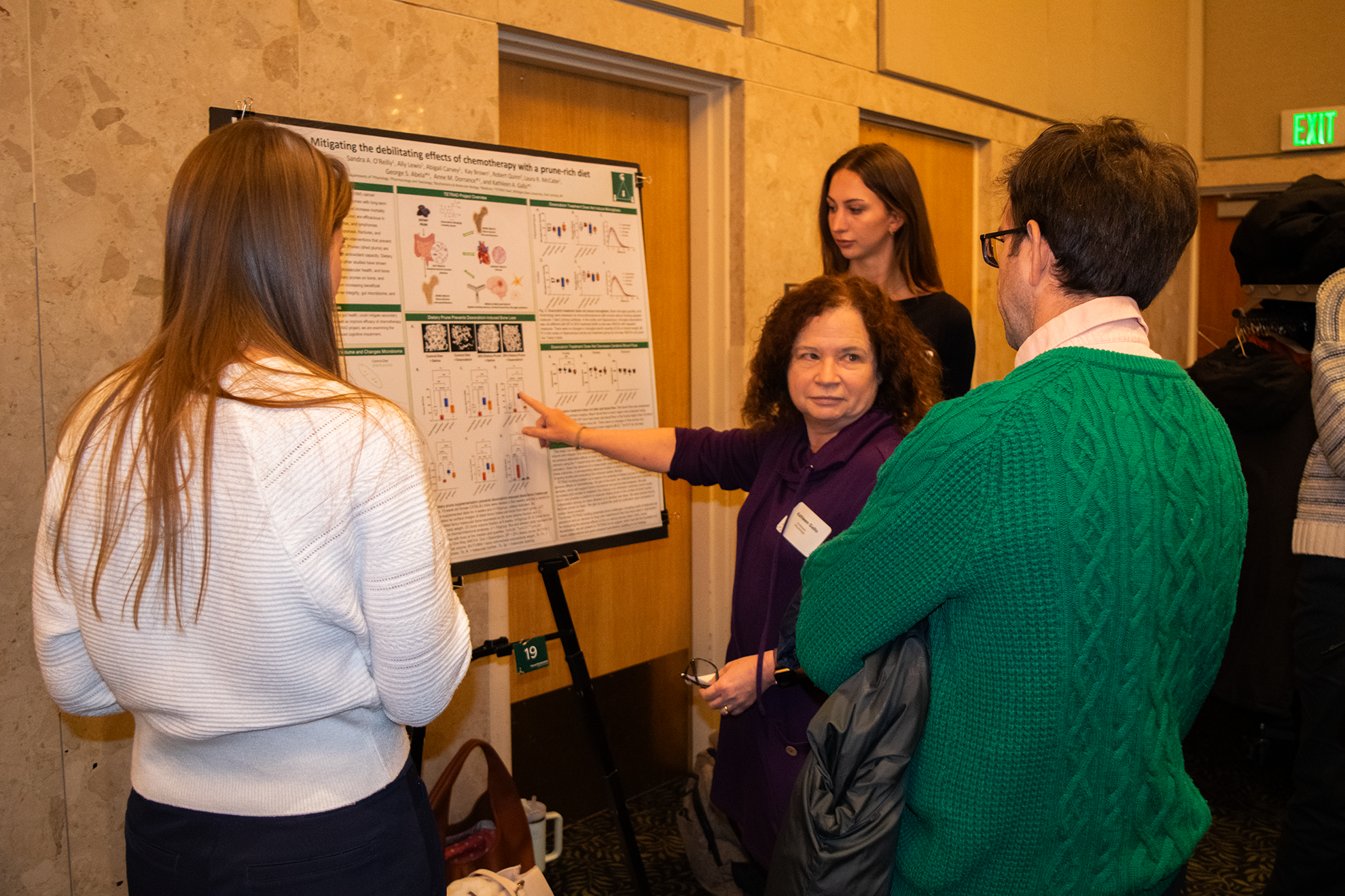 People talking in front of a research poster