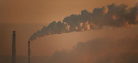 Gloomy image of factory stakes giving out smoke. 