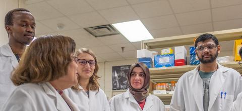 Five researchers standing together in a lab