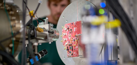 Man running equipment that is testing a electronic computer board