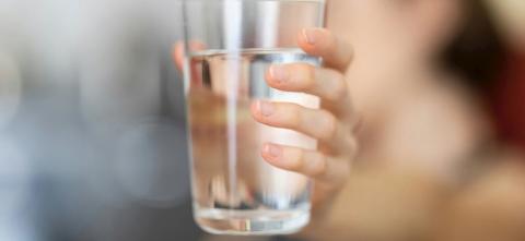 A person holding a glass of water
