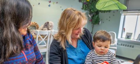 A person smiling holding a child