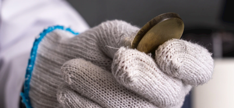 Gloved hand holding a metal circle