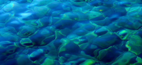 Close-up view of water with rippling patterns in shades of blue and green