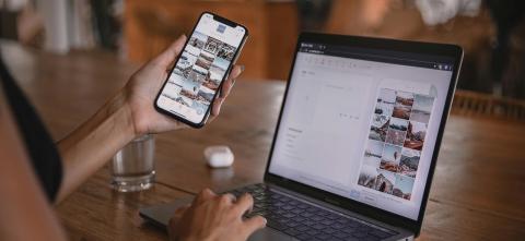 Person holding phone while using computer