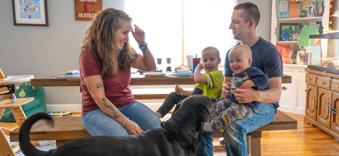 A family in a dining room with a dog