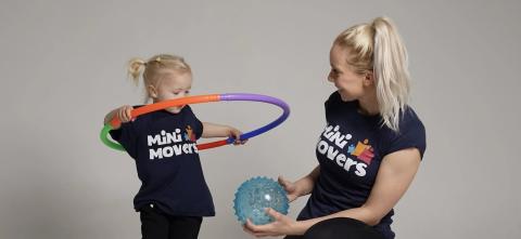 Person teaching child to hulahoop