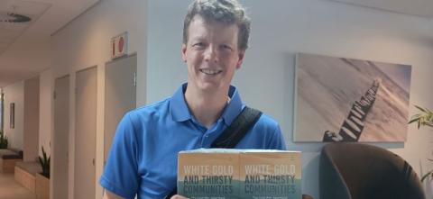 John Aerni-Flessner holding his book