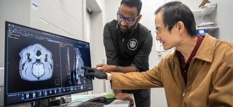 Chunqi Qian, Ph.D., points to imaging data displayed on a computer screen.