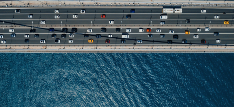 Cars on a bridge with blue water below