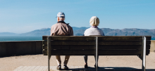 Two elderly people sitting on a bench