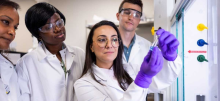 Carolina de Aguiar Ferreira and other researchers looking at a vial