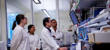 Researcher Xiaopeng and his team looking at a monitor