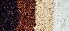 Four vertical rows of black rice, red rice, brown rice, and white rice