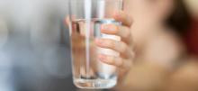 A person holding a glass of water