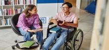 A person in a wheel chair talking to another person