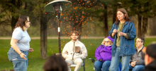 People acting while gathered around a campfire