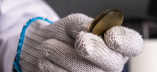 Gloved hand holding a metal circle