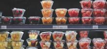 Fruits displayed in plastic containers at grocery store