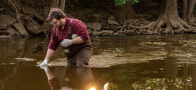 Citizen scientists wading in a stream to collect environmental data.