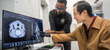 Chunqi Qian, Ph.D., points to imaging data displayed on a computer screen.