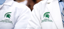 Two people wearing MSU College of Osteopathic Medicine lab coats